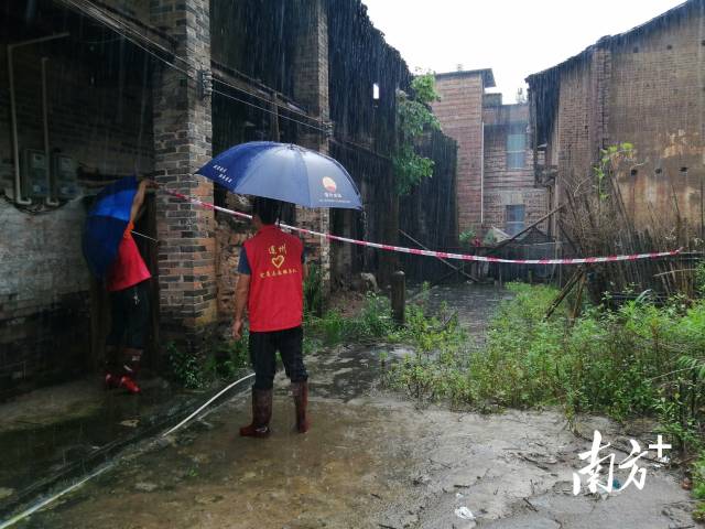 黨群志愿者冒雨拉起警戒線。