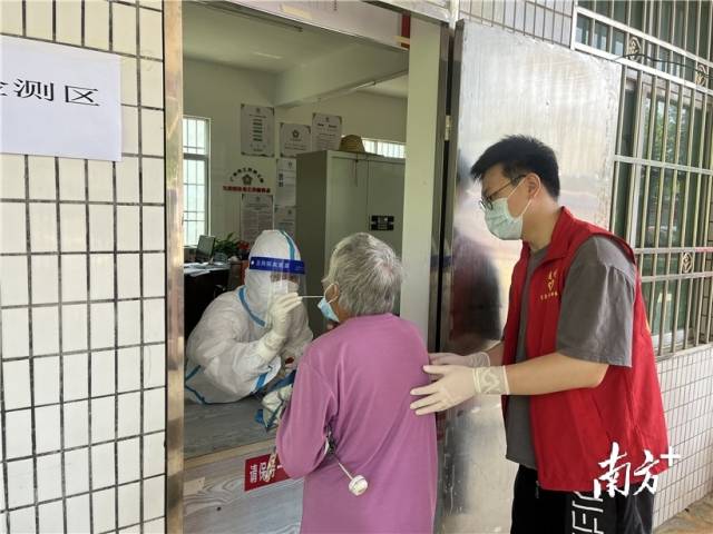 現(xiàn)場(chǎng)志愿者幫助行動(dòng)不便群眾接受核酸檢測(cè)。